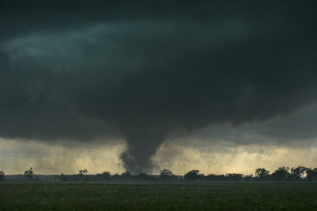 tornado touching down below a dark sky